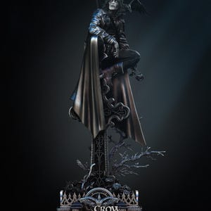 May include: A detailed statue of a figure in a black leather jacket and long coat, perched atop an ornate column. A crow rests on the figure's shoulder. The base of the statue reads "CROW" and "IN MEMORY OF BRANDON LEE".