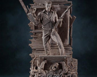 Op de afbeelding: Gedetailleerd beeld van een personage uit Evil Dead 2, met een kettingzaag en een shotgun. De figuur staat op een houten constructie met een schreeuwende zombie eronder. Het beeld is in grijstinten en bruin.