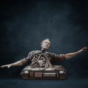 May include: A detailed sculpture of a man with exposed internal components, emerging from a rectangular base. The figure has a pale complexion, wearing a torn shirt, and outstretched arms. The base has mechanical details.