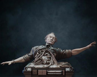 Op de afbeelding: Gedetailleerde sculptuur van een man met blootliggende interne componenten, die uit een rechthoekige basis komt. De figuur heeft een bleke teint, draagt een gescheurd shirt en uitgestrekte armen. De basis heeft mechanische details.