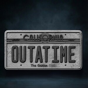 May include: A weathered, gray California license plate with the text "OUTATIME" in bold, black letters. The word "CALIFORNIA" is arched across the top. The phrase "The Golden" is at the bottom. The plate has a distressed, textured appearance.