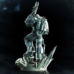 May include: A detailed, gray figurine of a futuristic soldier in a spacesuit, holding a weapon. The figure stands on a rocky base with crystalline structures, set against a dark background. The soldier has a backpack and various tubes.