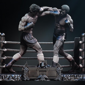 May include: A detailed sculpture of two boxers in a boxing ring. The figures are muscular, wearing boxing gloves and shorts. The ring has ropes and posts. The sculpture is set on a decorative base with an eagle emblem.