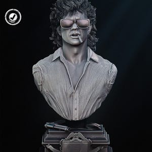 May include: A detailed bust sculpture of a man with sunglasses and a cigarette, wearing a button-down shirt. The sculpture is gray and rests on a tiered base with a gun and a license plate-like emblem. The background is black.