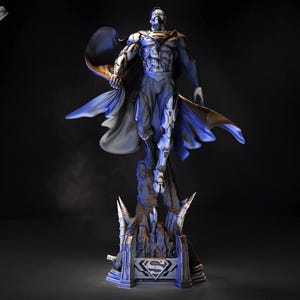 May include: A detailed statue of a superhero in a dynamic pose, featuring a blue and silver colour scheme with a flowing cape. The statue is mounted on a stylized base with a metallic emblem.
