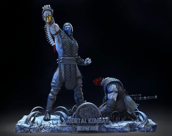 Peut inclure: Statue détaillée représentant une scène de Mortal Kombat, avec deux personnages en combat. L'un tient une tête coupée, tandis que l'autre est à genoux. La base indique "MORTAL KOMBAT SPINE RIP."