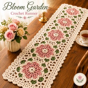 May include: A cream-colored crochet table runner with a floral design. The runner features large pink flowers with green leaves, and the text "Bloom Garden Crochet Runner" is at the top. A vase of pink roses and a teacup are also visible.