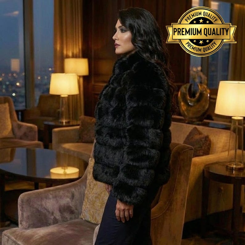 May include: A black faux fur jacket with a textured, horizontal design. The jacket has a high collar and is worn by a person in a luxurious setting. A gold-colored "Premium Quality" emblem is visible.