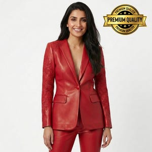Pode incluir: Um blazer de couro vermelho com detalhes bordados intrincados nas mangas. O blazer apresenta um fecho de um bot&atilde;o, lapelas entalhadas e dois bolsos frontais. A imagem tamb&eacute;m inclui cal&ccedil;as vermelhas a condizer. Um selo dourado com as palavras "Premium Quality".