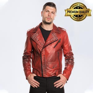 Può includere: Giacca in pelle rossa con borchie argentate su spalle, revers e maniche. La giacca ha un classico stile biker con colletto a revers, cerniera asimmetrica e tasche multiple. Prodotto di alta qualità.