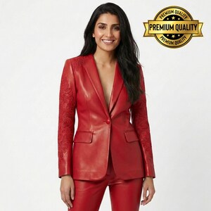 Pode incluir: Um blazer de couro vermelho com detalhes bordados intrincados nas mangas. O blazer apresenta um fecho de um bot&atilde;o, uma lapela entalhada e dois bolsos frontais. A imagem tamb&eacute;m inclui cal&ccedil;as vermelhas a condizer. Um selo dourado com as palavras "Premium Quality" est&aacute; no canto superior direito.