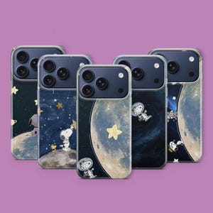 May include: Five phone cases with a space theme. Each case features a different design with Snoopy, stars, and planets. The cases have a clear border and a dark blue camera module.