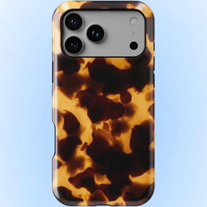 Może przedstawiać: Ochronne etui na telefon z wzorem szylkretu w odcieniach brązu i żółci. Etui ma prostokątny kształt z zaokrąglonymi rogami i wycięciem na aparat. Etui jest przeznaczone do smartfona.