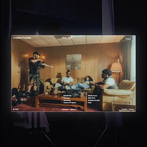 May include: A website template titled "Creative Portfolio" with a film set scene. The website's interface displays a living room setting with people. The template includes menu options and text such as "BOOZE Bar" and "Kinetic Form."