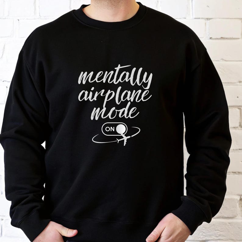 Może przedstawiać: Czarna bluza z białym napisem "mentally airplane mode" i grafiką samolotu. Słowo "ON" znajduje się pod grafiką samolotu. Bluza jest w stylu z okrągłym dekoltem.