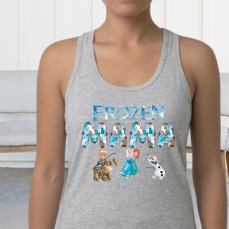 Pu&ograve; includere: Canotta grigia chiara con la scritta "FROZEN MAMA" in blu e bianco. La grafica include i personaggi dei cartoni animati del film Frozen, tra cui Anna, Elsa, Olaf e Kristoff.