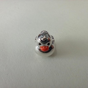 Peut inclure: Un petit charm argenté en forme de canard. Le charm a un bec rouge et un design détaillé sur la tête. Le charm canard est un accessoire mignon et fantaisiste.