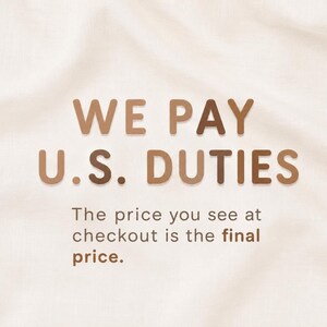 May include: A graphic display on a light cream fabric background featuring the brown text WE PAY U.S. DUTIES in a bold sans-serif font, followed by the smaller text The price you see at checkout is the final price in a matching brown colour.