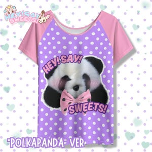 May include: A short-sleeved t-shirt featuring a panda design. The front of the shirt has a purple polka dot pattern, a panda face, and the words "HEY! SAY! SWEETS!". The sleeves are pink, and the text "POLKAPANDA" VER" is at the bottom.