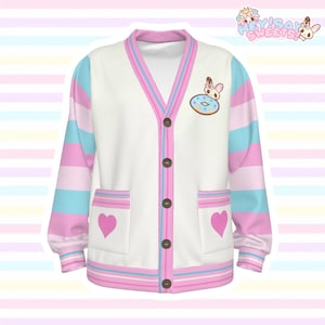 May include: A white V-neck cardigan featuring long sleeves with horizontal pink and light blue stripes. The front includes five brown buttons, two pockets each decorated with a pink heart, and a small graphic of a character sitting on a donut.