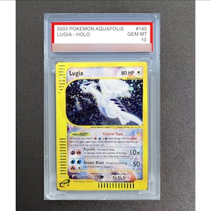 Op de afbeelding: Een 2003 Pokemon Aquapolis Lugia Holo ruilkaart met de beoordeling GEM MT 10, ingesloten in een doorzichtige plastic houder. De kaart toont een witte Lugia-illustratie tegen een donkere, sterrenhemel-achtergrond met gele randen.