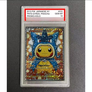 Può includere: Una carta Pokémon valutata con Pikachu vestito da Gyarados. La carta ha un design olografico con testo giapponese ed è racchiusa in una custodia protettiva. La carta è valutata GEM MT 10.