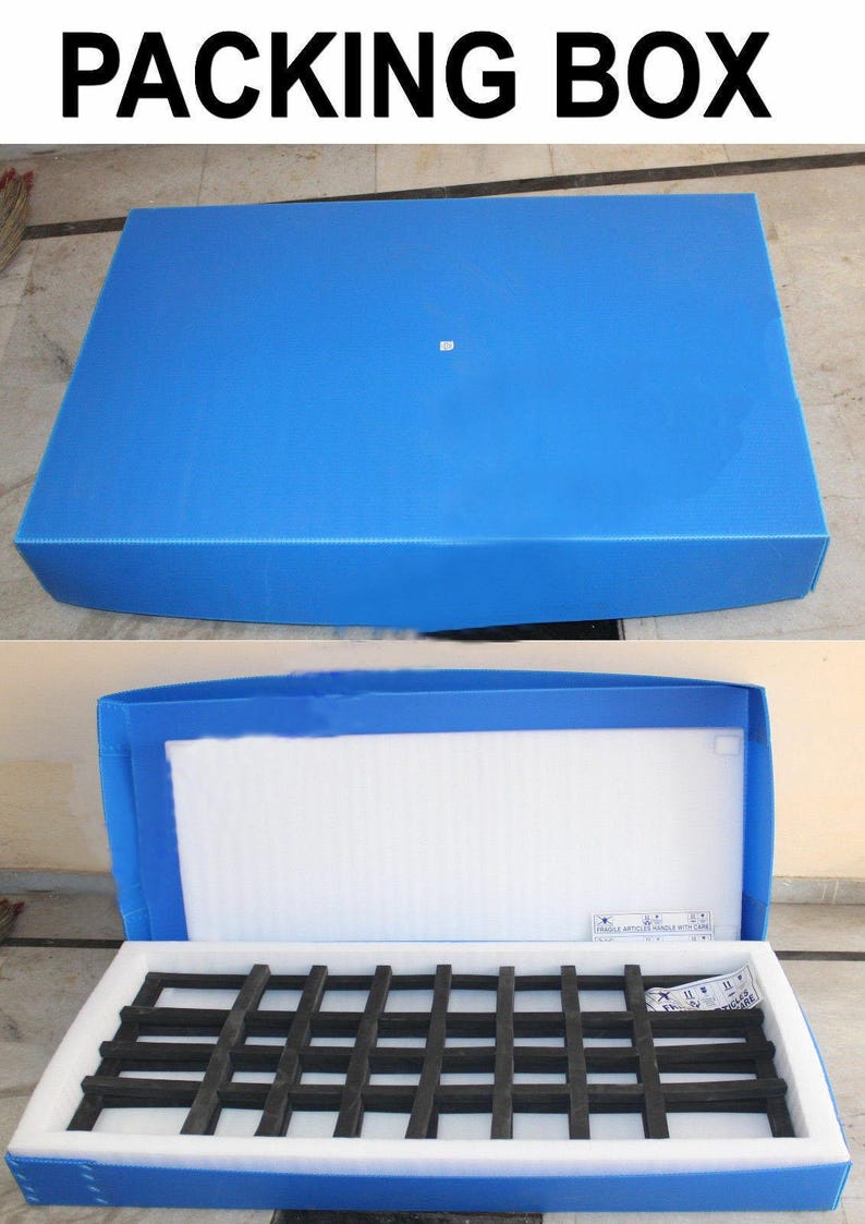 Puede incluir: Una caja de embalaje rectangular azul con el texto PACKING BOX en la parte superior. La caja se muestra cerrada y abierta, revelando un forro interior de espuma blanca y un inserto negro en forma de rejilla, con una etiqueta de fr&aacute;gil dentro.