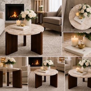 Puede incluir: Una mesa de centro redonda con una superficie de patr&oacute;n de m&aacute;rmol beige y tres patas de madera marr&oacute;n oscuro. La mesa est&aacute; decorada con un jarr&oacute;n blanco acanalado con flores blancas, una vela encendida en un frasco de vidrio, un cuenco dorado y un libro blanco.