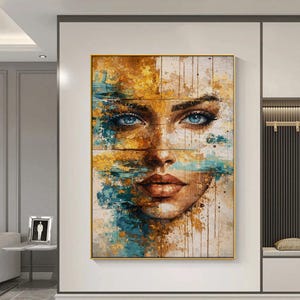 Puede incluir: Pintura de retrato abstracto enmarcada de un rostro femenino. La obra presenta unos llamativos ojos azules, una nariz definida y labios carnosos. La pintura utiliza una paleta de colores dorados, turquesa y marrón, con pinceladas visibles y un efecto texturizado.