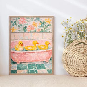Könnte beinhalten: Gerahmter Kunstdruck mit einer rosa Badewanne und drei gelben Gummienten. Der Hintergrund hat ein Blumenmuster und einen grün-blauen Schachbrettboden. Das Kunstwerk befindet sich in einem Holzrahmen.