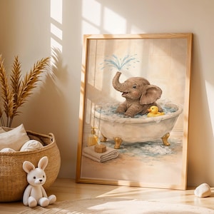 Könnte beinhalten: Ein gerahmter Aquarelldruck zeigt ein spielendes Baby-Elefanten in einer Badewanne. Der braune Elefant spritzt Wasser aus seinem Rüssel. Eine gelbe Quietscheente schwimmt im Schaum. Das Kunstwerk hat einen hellen Holzrahmen und ist für Kinderzimmer geeignet.