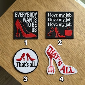May include: Four embroidered patches with red high heels and text. One patch says "EVERYBODY WANTS TO BE US". Another says "I love my job" multiple times. A circular patch says "That's all". The last patch says "THAT'S ALL".