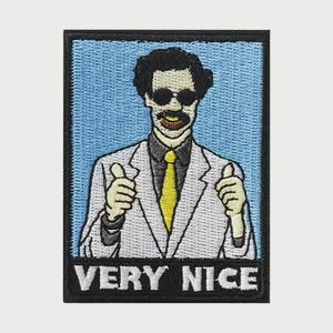May include: Embroidered patch featuring a cartoon figure in a white lab coat, sunglasses, and a yellow tie, giving a thumbs-up gesture. The text "VERY NICE" is displayed in white letters on a black background.