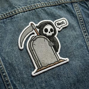 May include: Embroidered patch featuring the Grim Reaper holding a tombstone and scythe. The Reaper is black and white with a skull face. A speech bubble says "Next.". The patch is on a denim jacket.