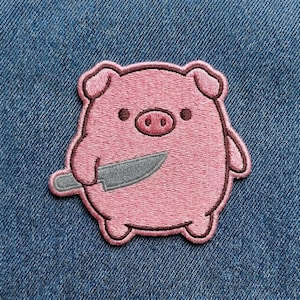 May include: Embroidered patch featuring a pink pig holding a gray knife. The pig has a round body, small ears, and a detailed snout. The patch is outlined in a darker pink thread, creating a distinct border. The background is a blue denim fabric.