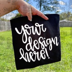 Puede incluir: Una taza de cerámica blanca con asa negra y el texto "But First, Coffee" en negrita negra. La taza se encuentra sobre un fondo borroso, sugiriendo un ambiente acogedor.