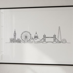 May include: Framed print with a black border, showcasing a minimalist line drawing of the London skyline. The artwork depicts famous landmarks like Big Ben, the London Eye, and Tower Bridge, in black against a white backdrop.