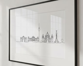 May include: Framed black and white line art print of the Berlin skyline. The artwork features iconic landmarks such as the Brandenburg Gate, the Berliner Dom, and the TV Tower. The print is displayed in a black frame.