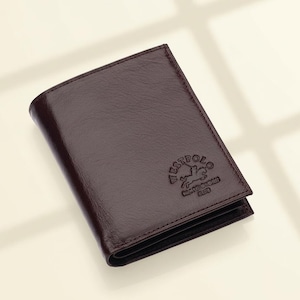May include: A dark brown leather wallet with a smooth, slightly textured finish. The front features an embossed logo of a polo player on a horse with the text WESTPOLO CLUB printed clearly below the graphic in a circular arrangement.