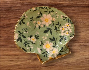 Adorno de joyería artesanal con flores en concha de vieira, forma única.