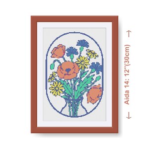 Op de afbeelding: Ingeklemd kruissteekkunstwerk met een boeket van oranje klaprozen, gele madeliefjes en blauwe korenbloemen in een vaas. De bruine lijst is 30 cm hoog. Het ontwerp is op Aida 14 stof.