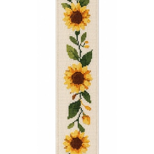 May include: A rectangular bookmark featuring a vertical cross-stitch pattern of three yellow sunflowers with brown centers, green leaves, and small yellow buds arranged on a cream-colored fabric background with a visible grid texture.