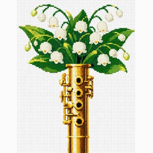 Könnte beinhalten: Ein Kreuzstichmuster mit einem goldenen Blechblasinstrument, das einem Fagott oder einer Oboe ähnelt und als Vase für ein üppiges Arrangement aus weißen Maiglöckchen mit leuchtend grünen Blättern vor einem weißen Rasterhintergrund dient.