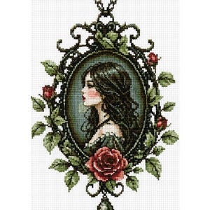 May include: A cross-stitch pattern featuring a profile portrait of a person with long dark hair, enclosed in an oval frame decorated with green leaves and red roses. A dark teardrop-shaped pendant hangs from the bottom of the ornate frame.