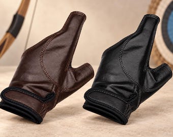 May include: Two archery gloves, one in dark brown and one in black, featuring a fingerless design with a reinforced palm section, exposed thumb and index finger, and a secure adjustable hook-and-loop wrist strap closure with black trim.