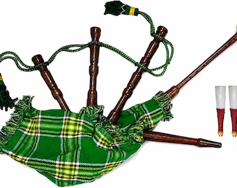 Op de afbeelding: Een traditionele doedelzak met een groen en geel geruite zak. Het instrument heeft donkerbruine houten pijpen, groene koorden en decoratieve kwasten. Twee rieten zijn ook zichtbaar.