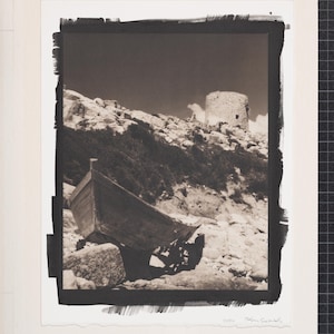 Könnte beinhalten: Schwarz-Weiß-Fotografie eines verwitterten Holzbootes an einem felsigen Ufer. Ein Steinturm steht auf einem Hügel im Hintergrund unter einem dunklen Himmel. Das Bild hat eine Vintage-Ästhetik.