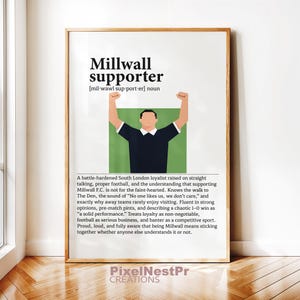 Peut inclure: Impression encadrée avec le texte "Millwall supporter" et sa définition. L'image présente un graphique d'une personne avec les bras levés, portant une chemise noire. L'impression comprend une description d'un supporter de Millwall.