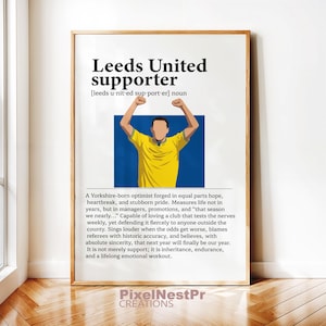 Puede incluir: Impresión artística enmarcada con las palabras "Leeds United supporter" en negrita negra. La impresión presenta un gráfico de una persona con una camisa amarilla con los brazos levantados, sobre un fondo azul. El texto describe a un aficionado del Leeds United.