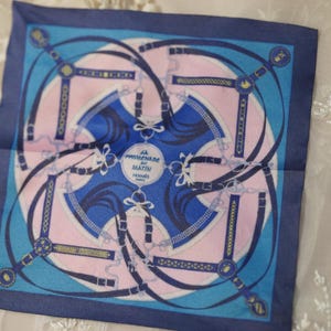 Blue and pink geometric 1/6 doll scarf laid flat beside a gold-framed mirror